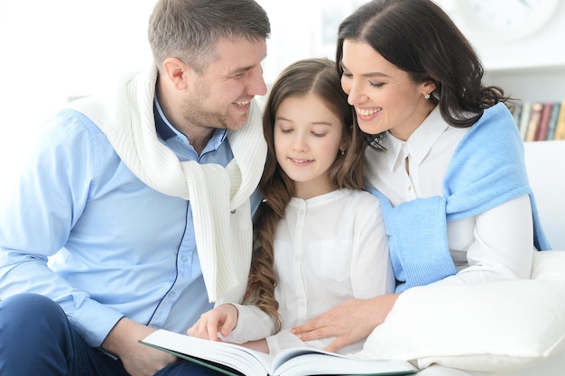 Ritratto di una famiglia con figlia che legge un libro