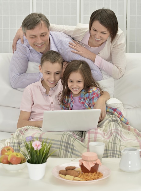 Ritratto di una famiglia felice con laptop in camera