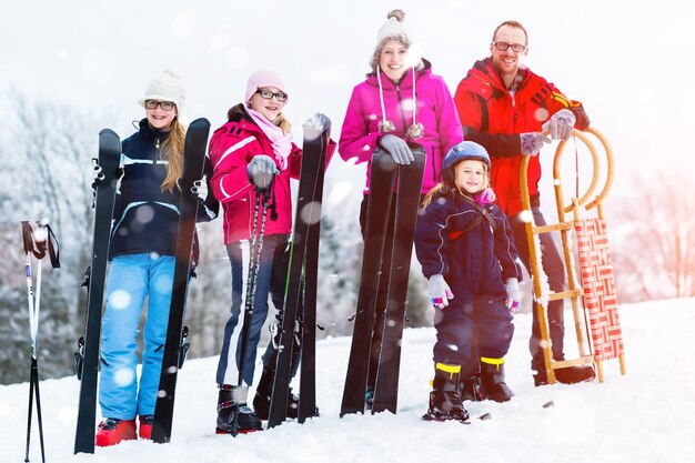 Ritratto di una famiglia felice con una tavola da snowboard in piedi su un terreno coperto di neve