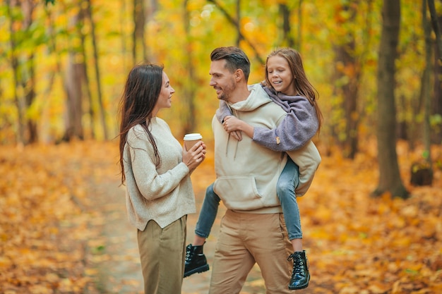 Ritratto di una famiglia felice di tre nel giorno di autunno