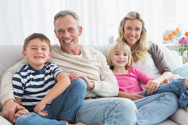 Ritratto di una famiglia sorridente seduto sul divano