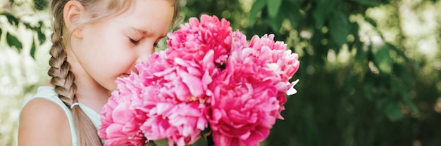 ritratto di una felice bambina di sette anni caucasica, tiene in mano e odora e si diverte