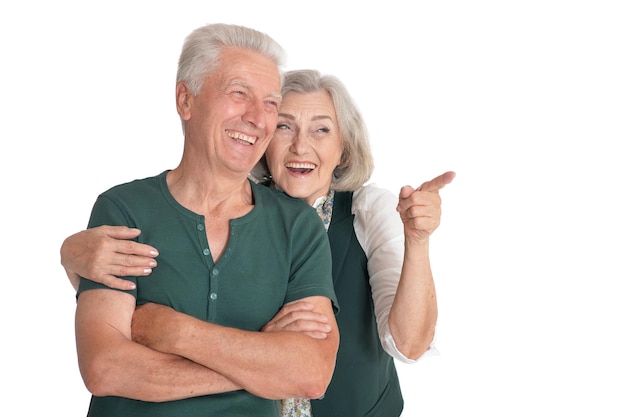 Ritratto di una felice coppia di anziani che indica a destra sullo sfondo bianco
