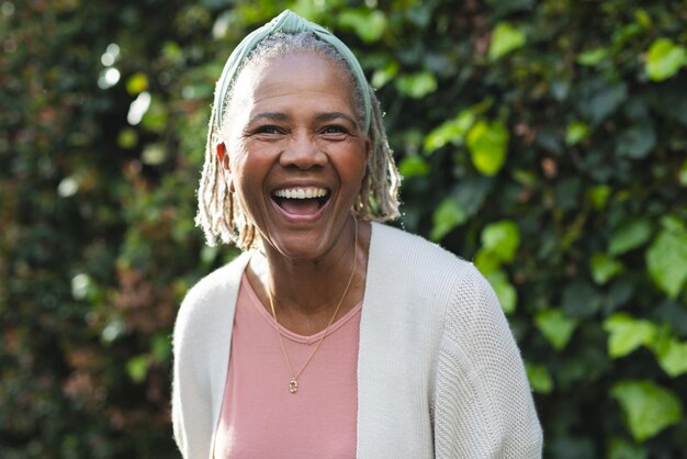 Ritratto di una felice donna afroamericana anziana in piedi in giardino