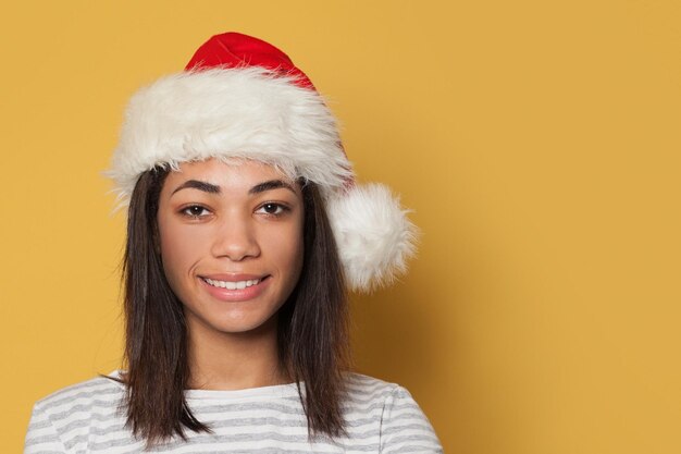 Ritratto di una felice donna afroamericana con il cappello di Babbo Natale