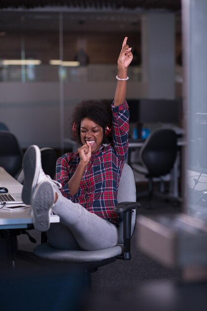 ritratto di una giovane bella donna afroamericana di successo che ama trascorrere un tempo gioioso e di qualità mentre lavora in un grande ufficio moderno