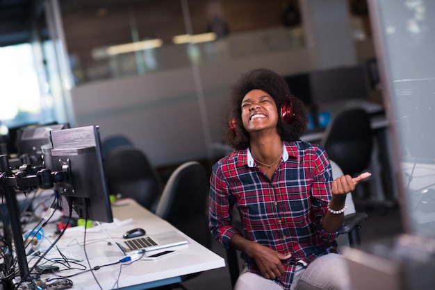 ritratto di una giovane bella donna afroamericana di successo che ama trascorrere un tempo gioioso e di qualità mentre lavora in un grande ufficio moderno