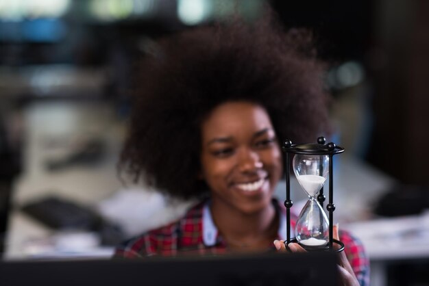 ritratto di una giovane bella donna afroamericana di successo che ama trascorrere un tempo gioioso e di qualità mentre lavora in un grande ufficio moderno