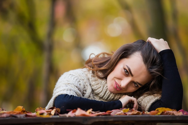 Ritratto di una giovane bella donna in un parco in autunno quando le foglie diventano colorate