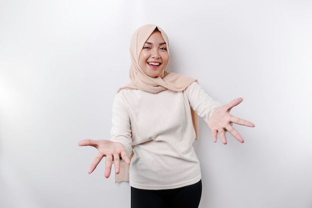 Ritratto di una giovane bella donna musulmana asiatica che indossa un velo che gesturing il saluto di Eid Mubarak