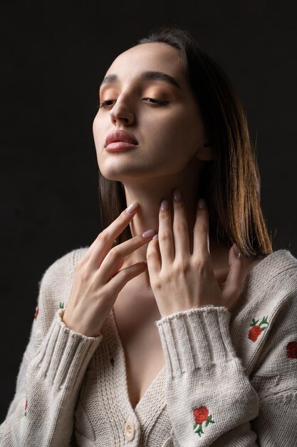 Ritratto di una giovane bruna con i capelli lunghi in studio Foto drammatica in colori scuri