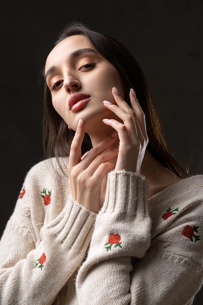 Ritratto di una giovane bruna con i capelli lunghi in studio Foto drammatica in colori scuri