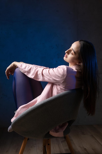 Ritratto di una giovane bruna con i capelli lunghi in studio Foto drammatica in colori scuri