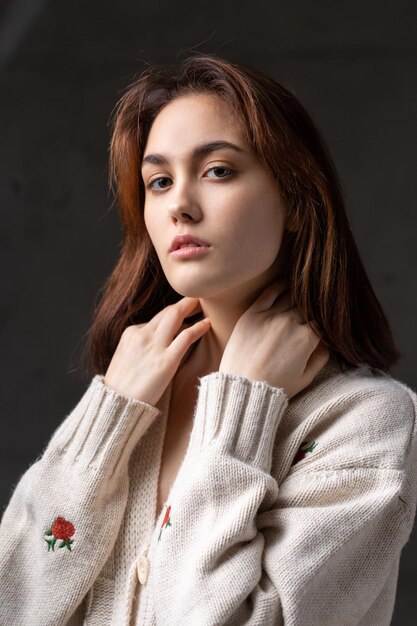 Ritratto di una giovane bruna con i capelli lunghi in studio Foto drammatica in colori scuri