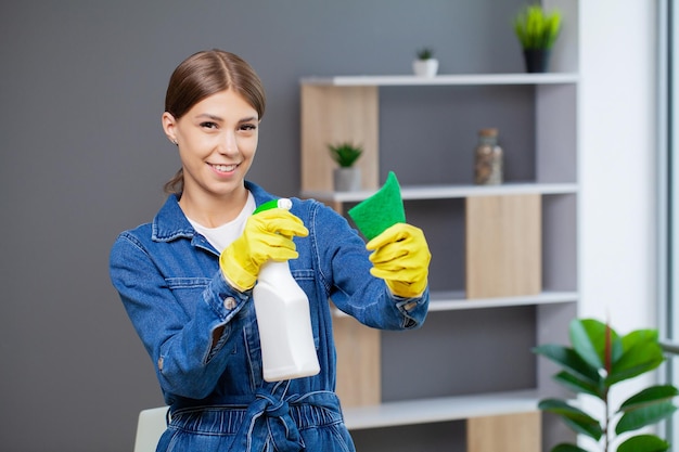 Ritratto di una giovane cameriera felice che sta pulendo l'ufficio