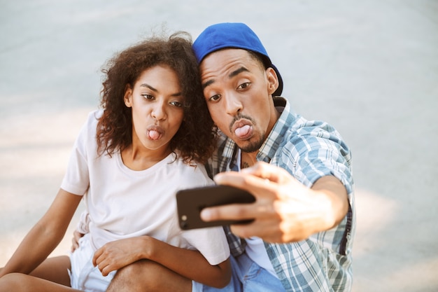 Ritratto di una giovane coppia africana felice prendendo un selfie