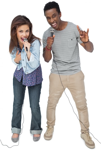 Ritratto di una giovane coppia che canta nei microfoni