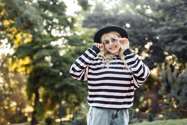 Ritratto di una giovane donna affascinante in maglione e cappello all'aperto