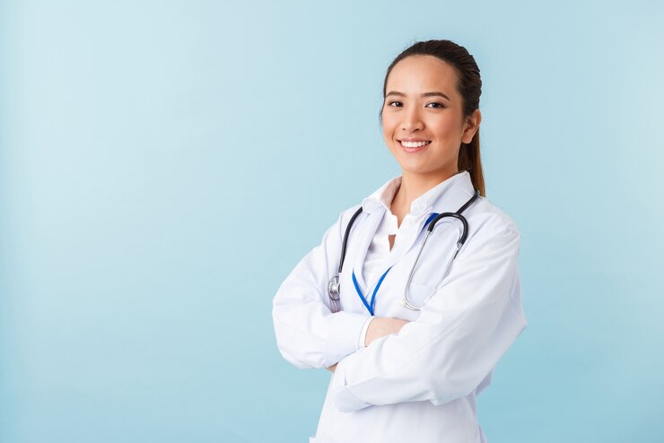 Foto ritratto di una giovane donna allegra felice medico in posa isolato su muro blu con lo stetoscopio.