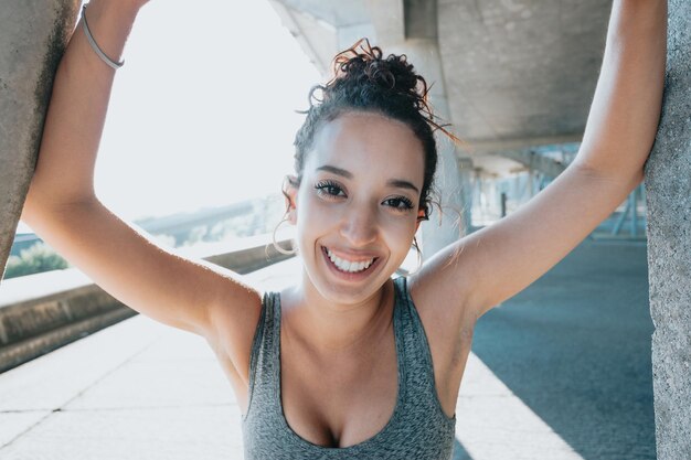 Ritratto di una giovane donna araba africana sorridente che sorride dopo aver fatto jogging all'aperto. Esercizio urbano all'aperto.