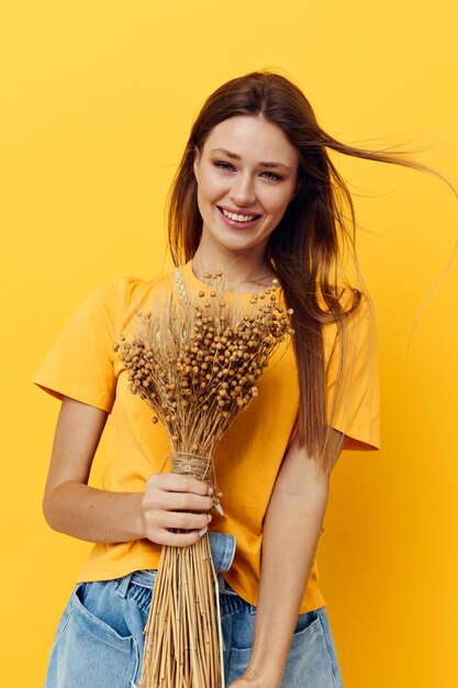 Ritratto di una giovane donna bouquet di fiori secchi abbigliamento casual sorriso in posa Stile di vita inalterato