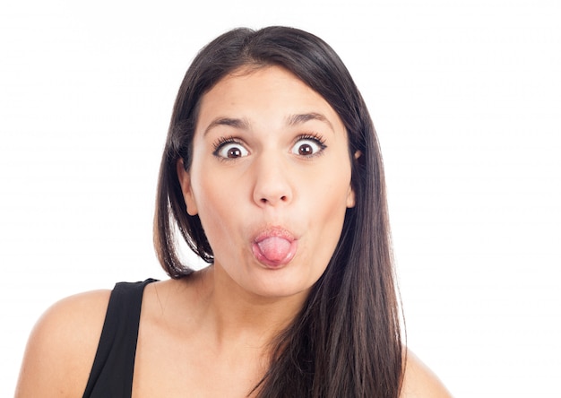 Ritratto di una giovane donna bruna felice ridendo e tirando la lingua