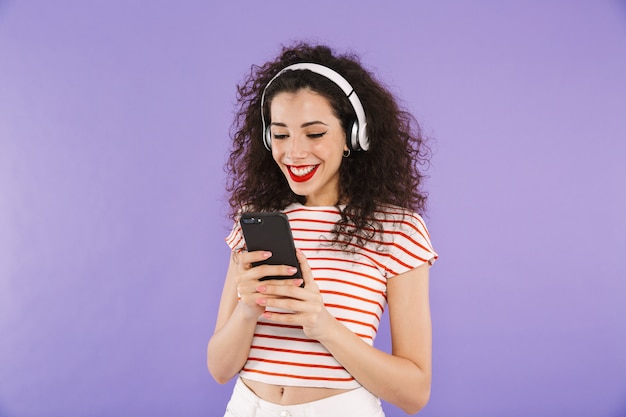 Ritratto di una giovane donna casual sorridente ascoltando musica