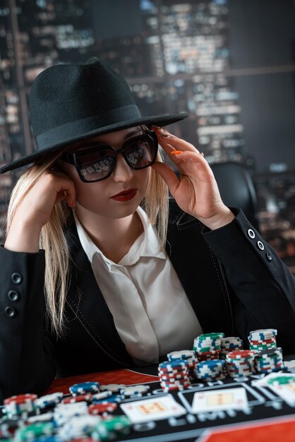 ritratto di una giovane donna caucasica con carte e fiches che gioca a poker al casinò