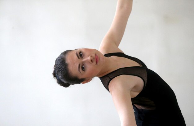 Ritratto di una giovane donna che balla il balletto su sfondo bianco