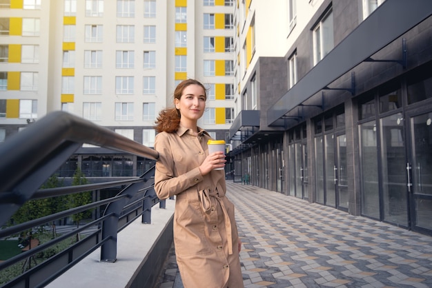 Ritratto di una giovane donna che beve il caffè in strada