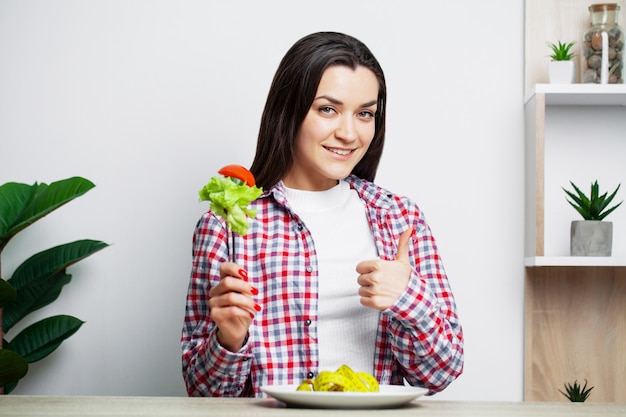 Ritratto di una giovane donna che mangia insalata