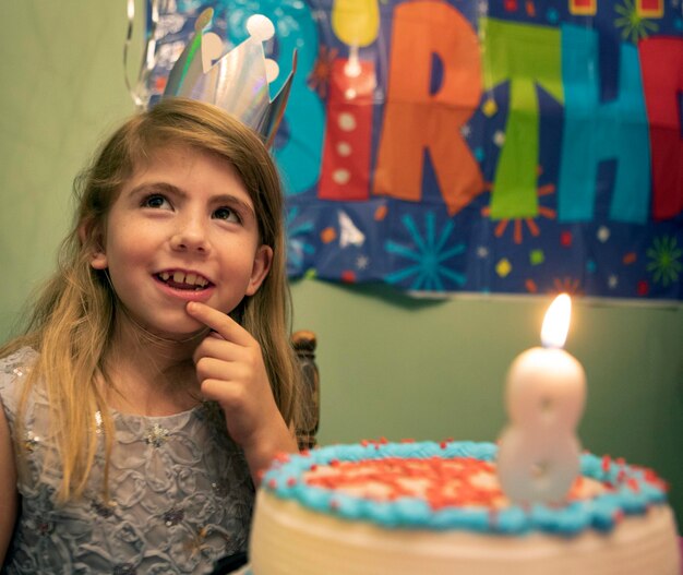 Ritratto di una giovane donna che soffia le candele di compleanno