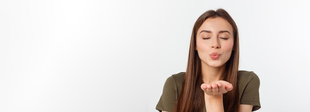 Ritratto di una giovane donna che soffia un bacio isolato su bianco