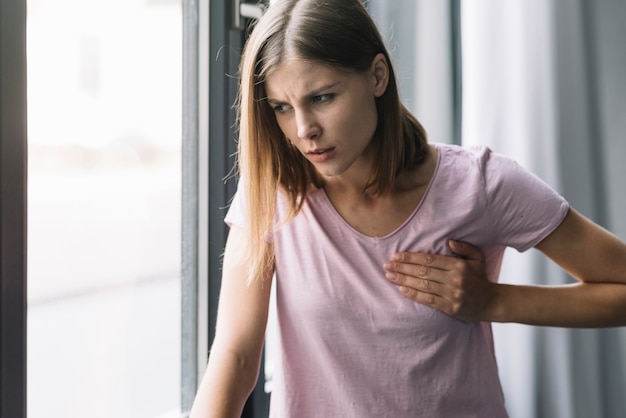 Ritratto di una giovane donna che tocca il petto dolorante