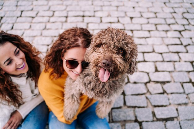 Ritratto di una giovane donna con un cane su un ciottolo