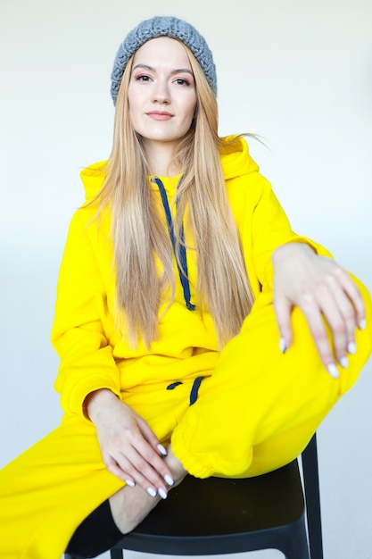 Ritratto di una giovane donna con un cappello invernale e una tuta da ginnastica gialla brillante