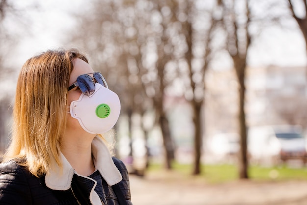 Ritratto di una giovane donna con una maschera protettiva sulla strada