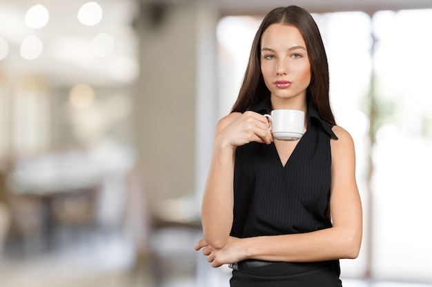 Ritratto di una giovane donna con una tazza di tè o caffè