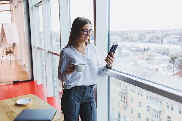 Ritratto di una giovane donna di successo che risolve problemi aziendali durante una conversazione telefonica, seduta in un moderno caffè. L'interno carino si sta godendo il suo tempo libero al bar.