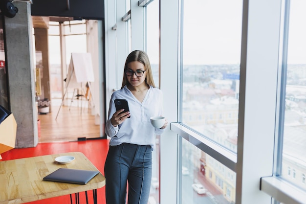 Ritratto di una giovane donna di successo che risolve problemi di lavoro durante una conversazione telefonica seduta in un moderno caffè Gli interni carini si stanno godendo il suo tempo libero al caffè