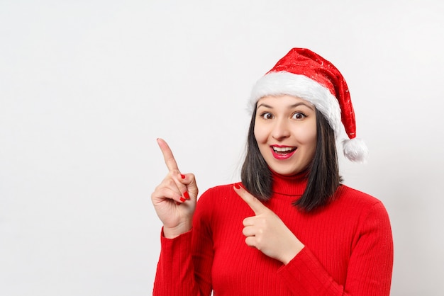 Ritratto di una giovane donna dolce sognante in un maglione rosso e cappello di Natale