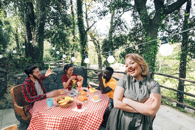 Ritratto di una giovane donna felice che si gode la compagnia di amici e ospiti sulla terrazza di casa per un caffè e uno spuntino