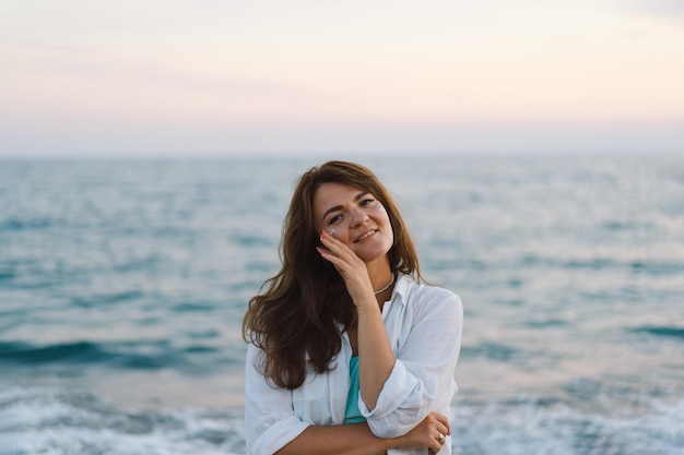 Ritratto di una giovane donna felice su uno sfondo di mare bellissimo La ragazza guarda il mare magico Libertà e felicità