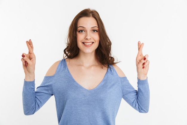 Ritratto di una giovane donna felice tenendo le dita incrociate