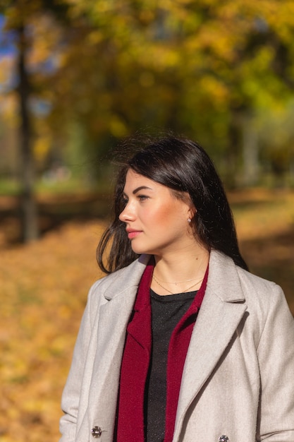 Ritratto di una giovane donna gioiosa che gode nel parco autunnale.