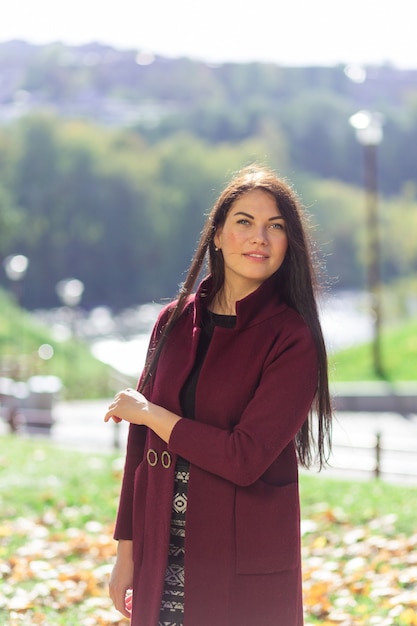 Ritratto di una giovane donna gioiosa che gode nel parco autunnale.