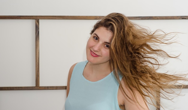 Ritratto di una giovane donna in piedi contro una parete bianca