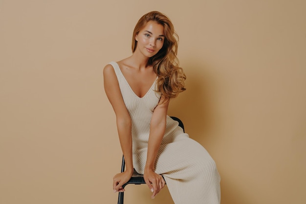 Ritratto di una giovane donna in piedi su uno sfondo rosa