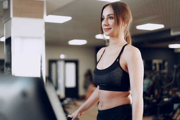 Ritratto di una giovane donna indoeuropea sportiva formazione in un fitness club