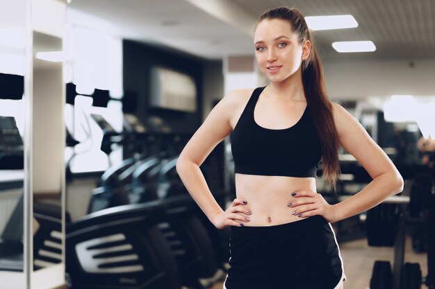 Ritratto di una giovane donna indoeuropea sportiva formazione in un fitness club